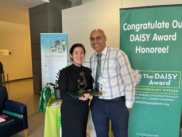 Two adults holding an award trophy