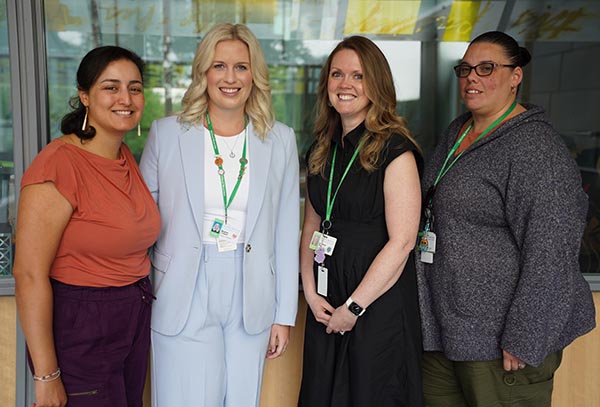 Four adults standing in an indoor setting