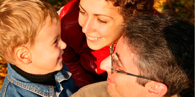 Parents and toddler smiling together.