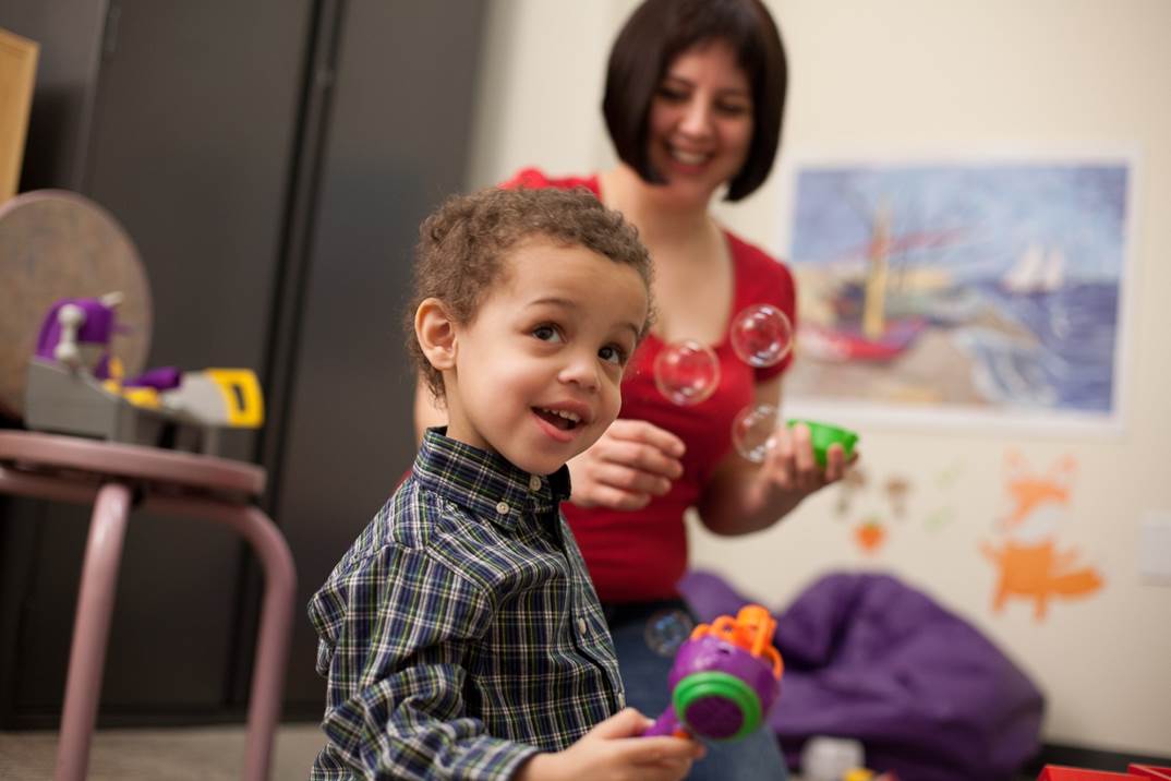 Boy and woman playing with bubbles.