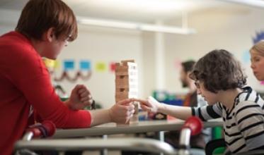 Staff and girl playing Jenga
