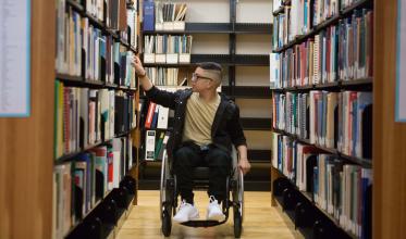 Youth looking through books in library