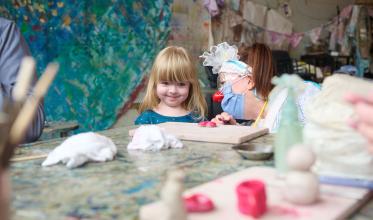 A toddler with smile on, talking with a clown