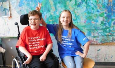 young boy using a wheelchair sitting with a friend