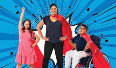 An adult with 2 children, all with their red cape on