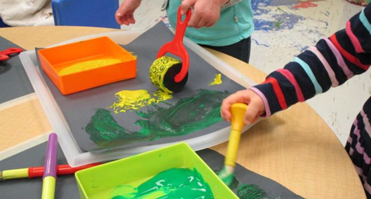 Two children painting the two different paint brushes