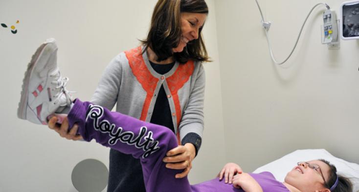 Female staff helping a girl lift her leg