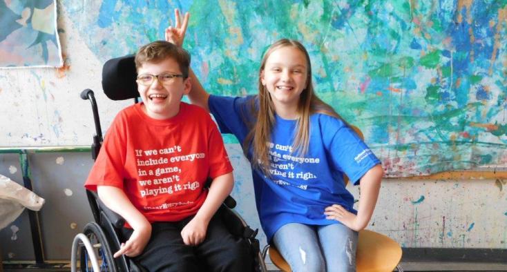 young boy using a wheelchair sitting with a friend