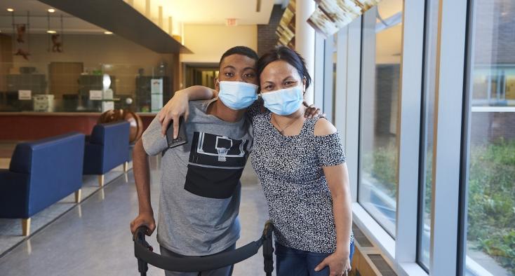 Teen with walker holding his mother