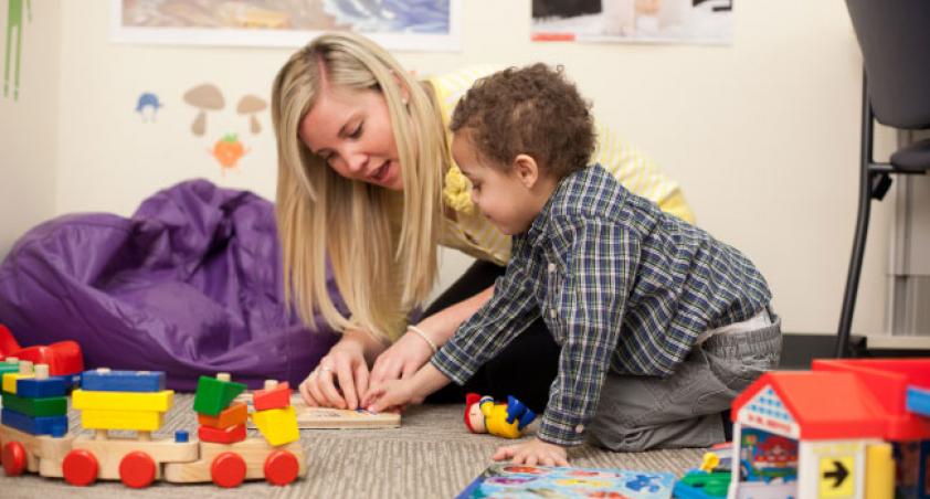 Research staff playing a board game with a child