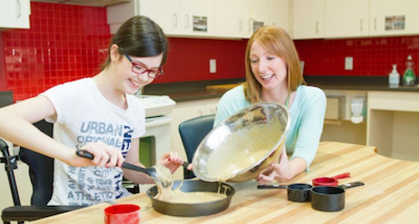 2 girls baking a cake