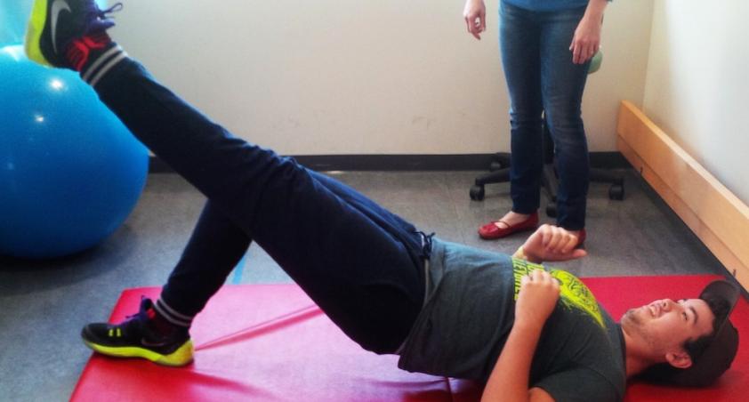 Boy lying down with one leg lifted off the ground