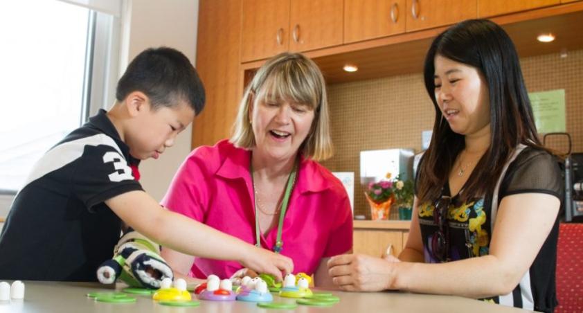 Two women and a boy playing with toys