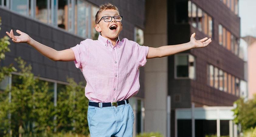 A child open up his arms in an outdoor setting