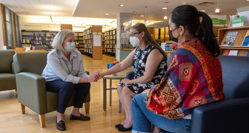 Three adults sitting and two holding hands