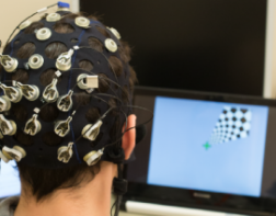 Person facing screen wearing BCI headset