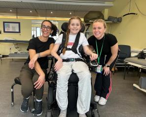 Two adults with a child on a wheelchair