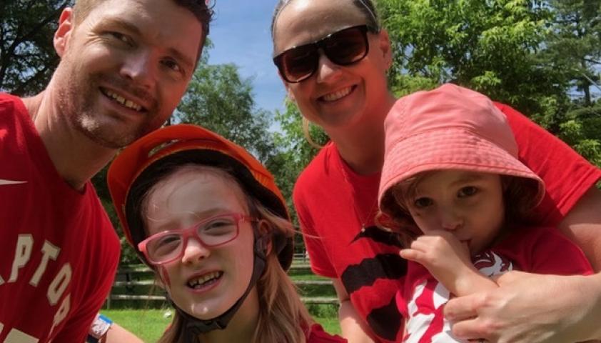 The family smiling at the camera on Canada Day. 