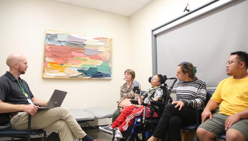 A consultant is meeting with a family and patient in a hospital