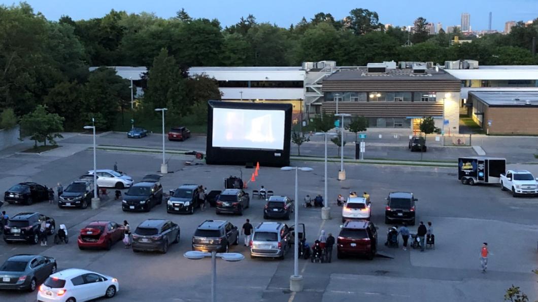 A wide view of the drive-in movie theatre in the parking lot. 