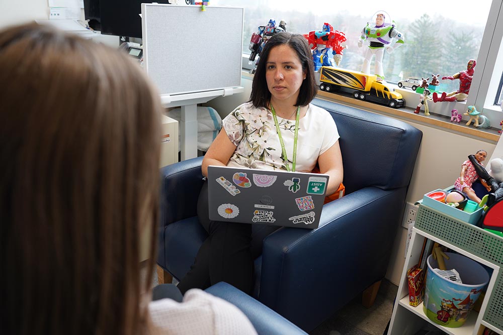 Leticia Toro is sitting on a chair while meeting with a client