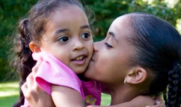 Girl holding a sibling close