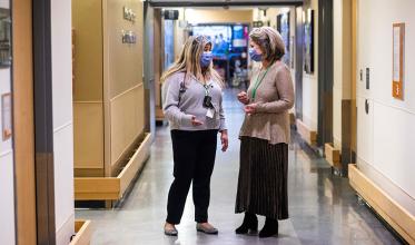 Two hospital staffs walking down the hallway