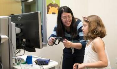 Scientist with girl using computer equipment