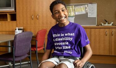 A child sitting on wheelchair with smile on face