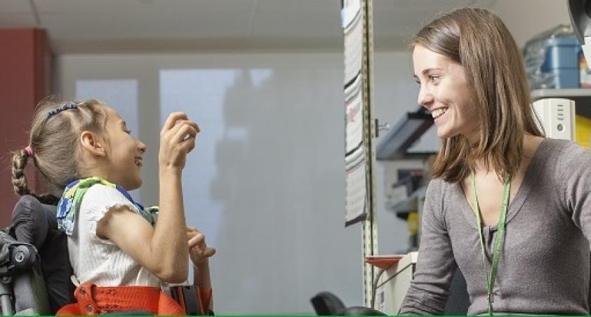 Woman playing with a girl in wheelchair