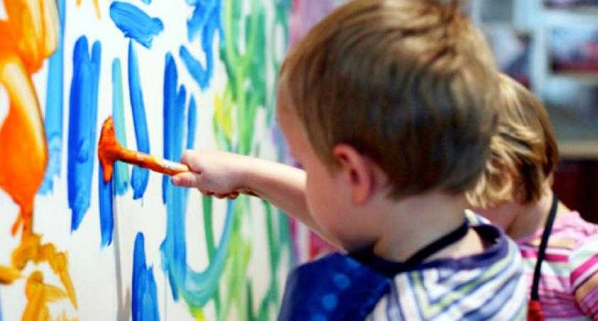 Little children painting a mural