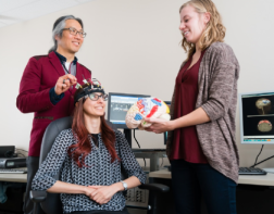 Staff explaining how the Brain-Computer interface works to a client.