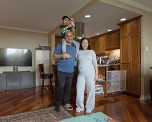 Man with young son on shoulders beside woman