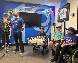 A group of people in an indoor setting, with some Blue Jays logos