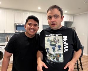Two young men with kitchen behind them