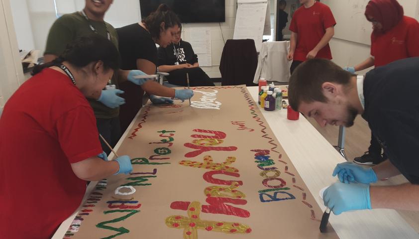 Students painting a thank you banner.