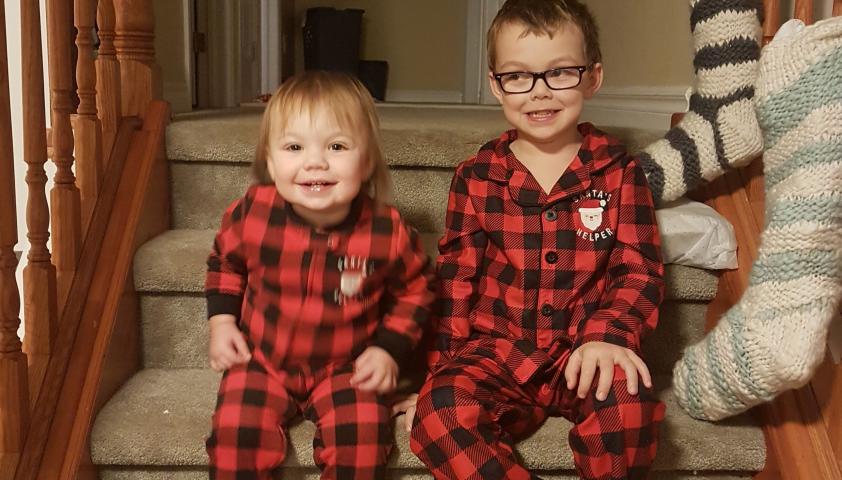 Alex with his sister wearing Christmas onesies. 