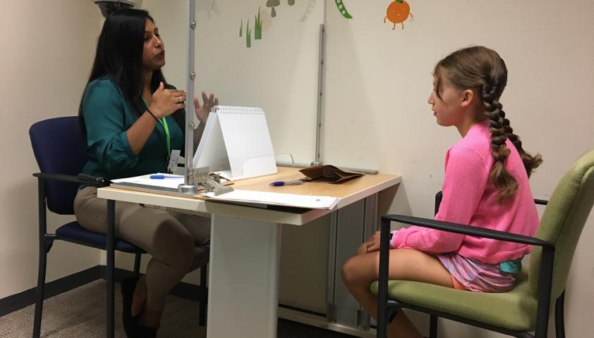 Dr. Teenu Sanjeevan, a research fellow in the institute’s Autism Research Centre, speaks to her research study participant, Amira Zarem, behind a plexi glass barrier to during one of the study's assessments.