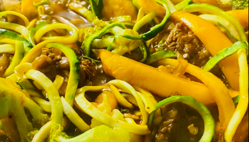 Close-up shot of beef stir fry with broccoli and zucchini and peppers.