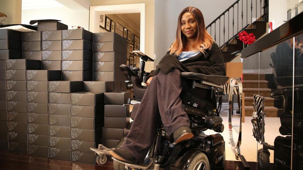 Young Black woman in wheelchair with boxes beside her